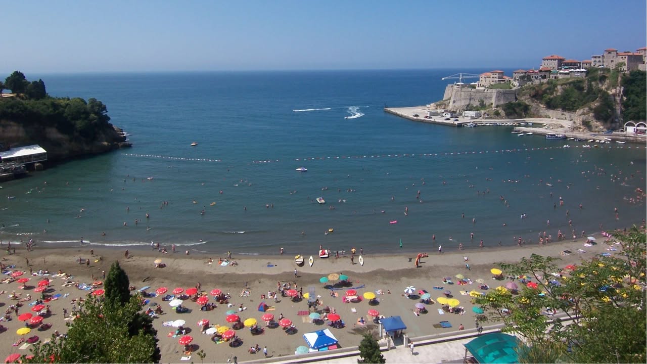 Ulcinj: Provjerili smo cijene. Cjenovnici na Maloj plaži „prepisani“ od prošle godine Prema saznanjima Plus portala, vlasnici apartmana i privatnog smještaja u Ulcinju, pored Male plaže, odlučili su da, uprkos rastu svih troškova, ne prate trend poskupljenja, već su cijene gotovo prepisali sa menija od prošle godine. Smještaj: Cijene pod kontrolom • Jednokrevetna soba: Cijene se kreću od 40 do 50 eura. • Dvokrevetna soba sa doručkom: Košta oko 100 eura. Domaćini ističu da su svjesni kupovne moći gostiju i da su korigovali cijene znatno manje nego što su porasli njihovi troškovi održavanja i komunalnih usluga. Cjenovnik u kafićima i restoranima • Pica: Od 5 do 10 eura (zavisno od vrste i veličine). • Pomfrit: 2,00 eura. • Dojč kafa: 2,60 eura. • Espresso: 1,20 eura. • Ness kafa: 2,20 eura. • Coca-cola: 2,20 eura. Ko su gosti Ulcinja? Struktura turista na Maloj plaži ove godine je jasna. Dominiraju gosti sa Kosova, dok je broj posjetilaca iz Bosne i Hercegovine i Novog Pazara nešto manji. Najjači talas gostiju, prema procjenama ugostitelja, zapravo počinje tek ovog vikenda. prema trenutnim procjenama, trajaće do 20. avgusta. Sezona jeste kraća u špicu, ali se "razvlači" na period koji je nekada bio nezamisliv, tako da sada traje do oktobra. “Sve se promijenilo, čak ni more nije isto. Nikad more u junu nije mjerilo temperaturu 27 stepeni. Zamislite kako će tek biti toplo u julu i avgustu", priča nam jedan od ugostitelja sa Male plaže. "Tačno je da je udarni termin kraći, ali sada imamo turista i u aprilu i u oktobru. To je ta nova realnost – sezona više nije jedan veliki talas, već niz manjih koji se protežu kroz čitavu godinu", zaključuje naš sagovornik.