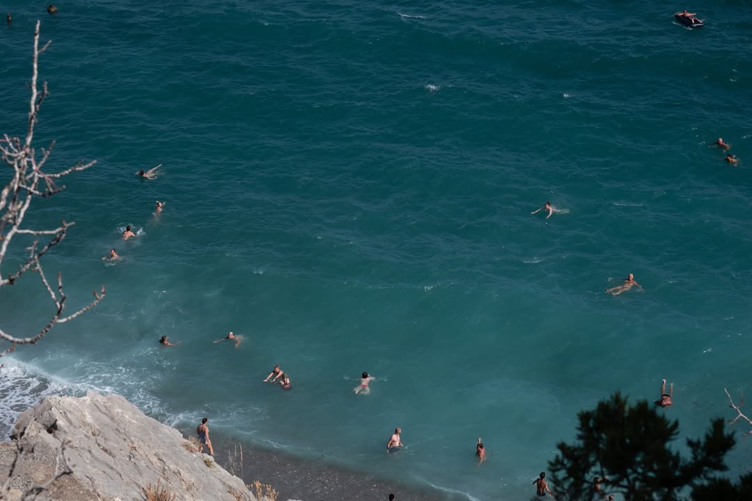 More vruće kao supa. Ni na pučini od 28 stepeni nema osvježenja Temperatura mora od čak 28 stepeni izmjerena u Herceg Novom i Baru potvrdila je ono što kupači već danima osjećaju na koži – ovo ljeto ne popušta. „Rođena sam Baranka. Bilo je i ranijih godina vruće, ali ne ovako. Klime nismo imali, sad bez njih ne možemo“, priča nam jedna Baranka, ističući da su vrućine postale intenzivnije i da traju duže nego prije. „U ovo doba godine već bi osjetili da sunce popušta, ali ove godine nije tako – i dalje peče i prži.“ Da je situacija alarmantna i u samom akvatorijumu, potvrđuju i posjetioci primorja. Bračni par iz Trebinja kaže da ni u moru više nema prijeko potrebnog osvježenja. „Kad izađemo iz mora, dok dođemo do peškira kupaći je suv. Suncobran ne pomaže, jer vrelina nije samo od sunca, vazduh je vruć. More isto toplo. Čak smo muž i ja riješili da plivamo ka pučini ne bi li malo bilo svježije i ništa. Ne pomaže ni kad zaronimo“, prepričavaju oni svoju borbu sa vrelim talasima. Prema najavama meteorologa, na Jadranu se i narednih dana nastavlja stabilno, sunčano i vrelo vrijeme, uz vedre i vrlo tople noći na jugu, te tek blago umirivanje uz popodnevni maestral.